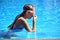Cute girl enjoys in swimming pool at the hotel.  teenager at resort in water. swimming training. Holidays with children at sea.