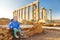 Cute girl exploring the Ancient Greek temple of Poseidon at Cape Sounion, one of the major monuments of the Golden Age of Athens