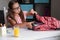 Cute girl in eyeglasses packing backpack, preparing for school