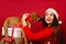 A cute girl with favorite puppy on the holiday boxes. Red background, holidays