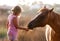 Cute girl feeding her handsome horse