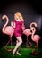 Cute girl in fuchsia sequins dress resting and dancing with three big flamingos on black background