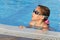 Cute girl in goggles swimming in pool
