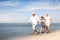 Cute girl with grandparents spending time together on sea beach