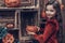 Cute Girl in Halloween Costume with Carved Pumpkin