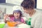 Cute girl with her mother bake cookies at home