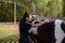 Cute girl holds a brush in her hand and cleans her horse in the equestrian club
