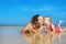 Cute girl kissing happy smiling mother on sea beach