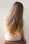 Cute girl with long blond hair. Back view of little girlie looking on side. Isolated on light background