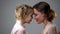 Cute girl and mother touching foreheads, female friendship, family support