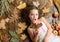 Cute girl with natural blond hair. Small beauty model with fall look. Little girl with wavy hairstyle on fall background