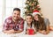 Cute girl opening a magical present on a Christmas morning with her family