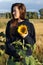 Cute girl  outdoor in the wilderness with sunflower in blue sweater,