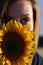 Cute girl  outdoor in the wilderness with sunflower in front of her face