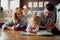 Cute girl with parents play with puzzle indoor