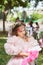 Cute girl in a pink puffy dress in the park