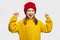 Cute girl raises arms, feels fantastic, wears yellow hoodie, laughs joyfully
