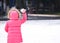 Cute girl ready to throw snowball during day, perspective from b