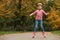 Cute girl roller skating in autumn park