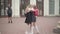 Cute girl running and hugging classmate after school holidays. Blurred boy standing with soccer ball at the background