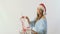 Cute girl in santa`s hat waves a decorative stick with ribbons above the gifts
