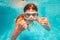 Cute girl in scuba mask swim and pose underwater