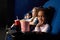 Cute girl sitting in cinema with friends, looking at camera.