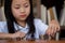 Cute girl sitting in library putting money coin to stack on table,saving money concept