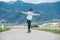 Cute girl skateboarding on the longboard on the asphalt road with a mountain landscape background. She gracefully balancing when