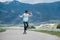 Cute girl skateboarding on the longboard on the asphalt road with a mountain landscape background. She gracefully pushing off and