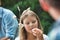 Cute girl smiling while holding stick with marshmallows at park