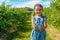 Cute girl standing and holding in her hands blueberries on the b