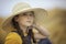 Cute girl in a straw hat, sitting in a field of hay in Eagle Mountain, Ut.