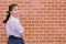 Cute girl teen student with uniform happy smile with school campus brick wall copy space