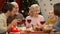 Cute girl telling funny story to adults at holiday dinner, family celebration