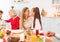 Cute girl touching noses with mom at festive table, celebrating family holiday together with her nears at home