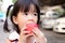 Cute girl is using her hand to hold an apple and bite it with deliciousness. Asian child eat fresh red fruit. Soft focus. Little