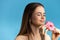 Cute girl wants to eat a pink glaze donut. Temptation food. Studio shot. Isolated over on blue background