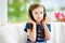 Cute girl wearing huge wireless headphones. Pretty child listening to the music. Schoolgirl having fun listening to kid`s songs at