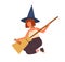 Cute girl in witch hat sitting and combing broom. Young female magician or wizard portrait. Funny sorcerer with red hair