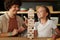 Cute girl with wooden block looking at high stack or tower while building it