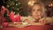 Cute girl writing letter for Santa on table decorated for Christmas, wish list