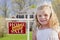 Cute Girl in Yard with Sold For Sale Real Estate Sign and House