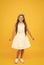 Cute girly girl. Happy girl yellow background. Fashion look of small girl. Little girl wear long brunette hair. Beauty