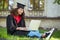 A cute graduate in academic gown having a vieo call and feeling happy