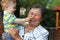 Cute grandson grabbing nose of great grandmother