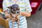 Cute gray and fawn teacup chihuahua puppy being held by young boy.