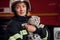 Cute grey colored scottish fold cat is in the hands of woman\\\'s firefighter that is in uniform at work in department