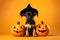 Cute Halloween puppy dog wearing hat sitting with jack-o-lantern pumpkins