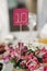 Cute handmade table number close-up at wedding reception in luxury restaurant, table number sign on flowers bouquet at restaurant